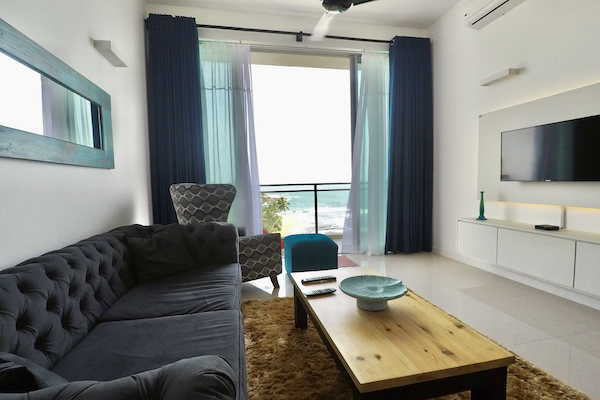 En bild på lägenhetens vardagsrum med havsutsikt.